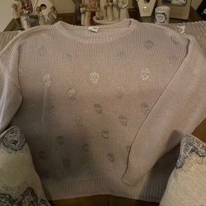Pink sweater with silver skulls.